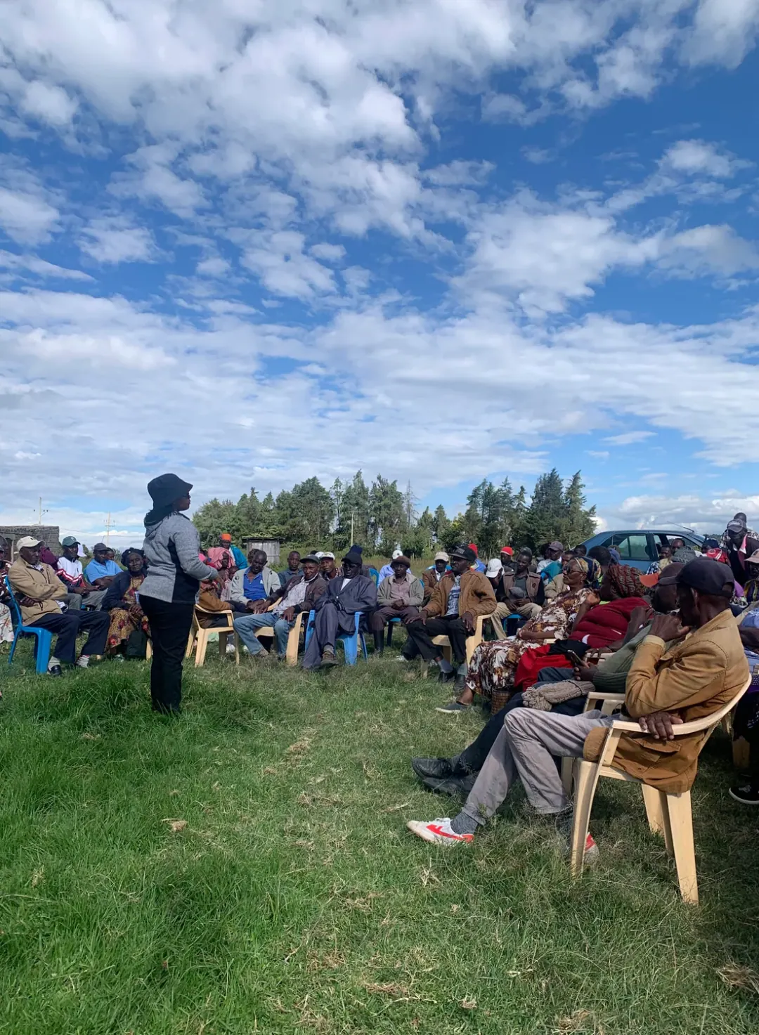 Mt Kenya farmers gathered in a circle with a woman speaking